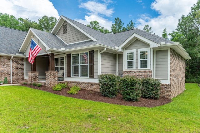 2580 Taylor Rd, Crestview, FL 32536 - view of front facade featuring brick siding, a front yard, covered porch, and a shingled roof