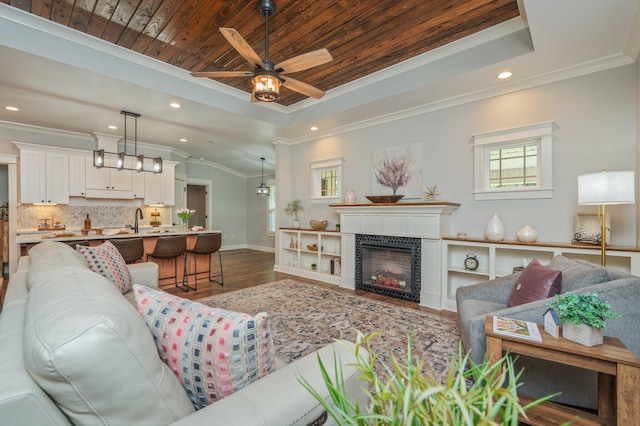 2580 Taylor Rd, Crestview, FL 32536 - living room featuring a raised ceiling, wood finished floors, crown molding, ceiling fan, and recessed lighting