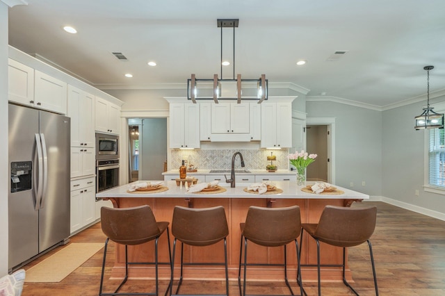 2580 Taylor Rd, Crestview, FL 32536 - kitchen with stainless steel appliances, wood finished floors, ornamental molding, light countertops, and decorative backsplash