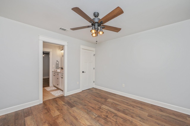 2580 Taylor Rd, Crestview, FL 32536 - unfurnished bedroom with wood finished floors, connected bathroom, and ceiling fan