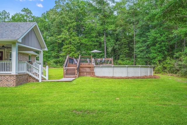 2580 Taylor Rd, Crestview, FL 32536 - view of green lawn with stairs, a deck, a ceiling fan, and an outdoor pool