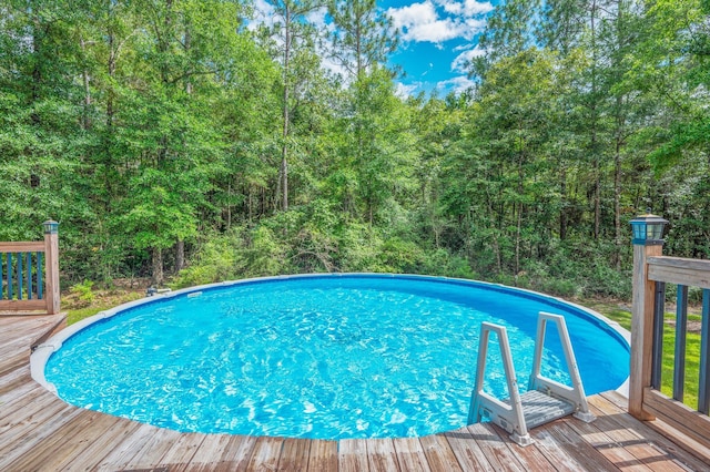 2580 Taylor Rd, Crestview, FL 32536 - outdoor pool with a wooden deck and a view of trees