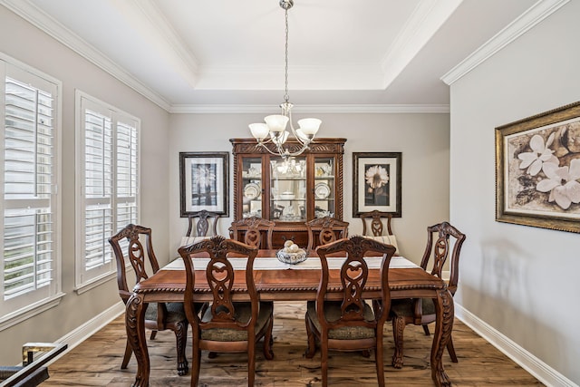 419 Symphony Way, Freeport, FL 32439 - dining space featuring a chandelier, wood finished floors, a raised ceiling, and ornamental molding