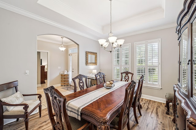 419 Symphony Way, Freeport, FL 32439 - dining space featuring arched walkways, a chandelier, light wood finished floors, a raised ceiling, and ornamental molding