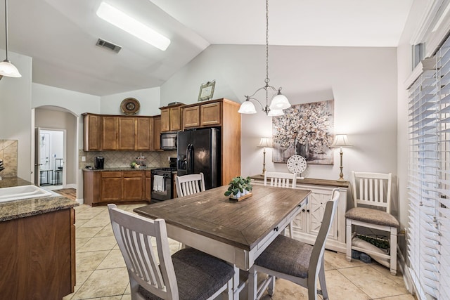 419 Symphony Way, Freeport, FL 32439 - dining area with arched walkways, light tile patterned flooring, a chandelier, and high vaulted ceiling