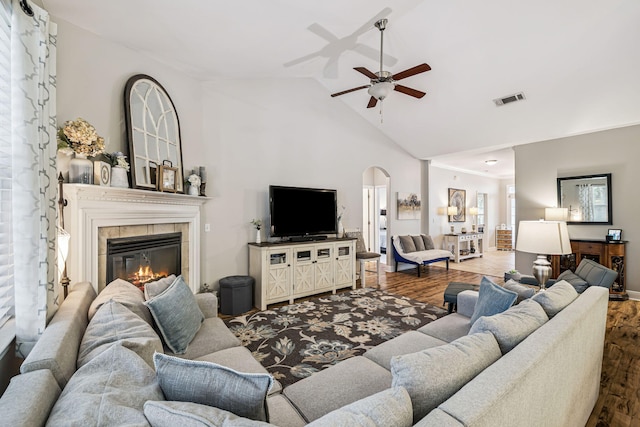 419 Symphony Way, Freeport, FL 32439 - living room featuring wood finished floors, a ceiling fan, arched walkways, high vaulted ceiling, and a tiled fireplace