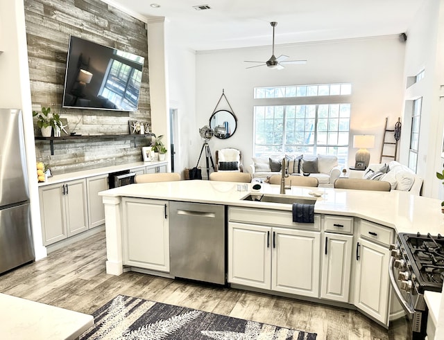 83 Azure Pl, Miramar Beach, FL 32550 - kitchen featuring stainless steel appliances, ornamental molding, a ceiling fan, open floor plan, and light countertops