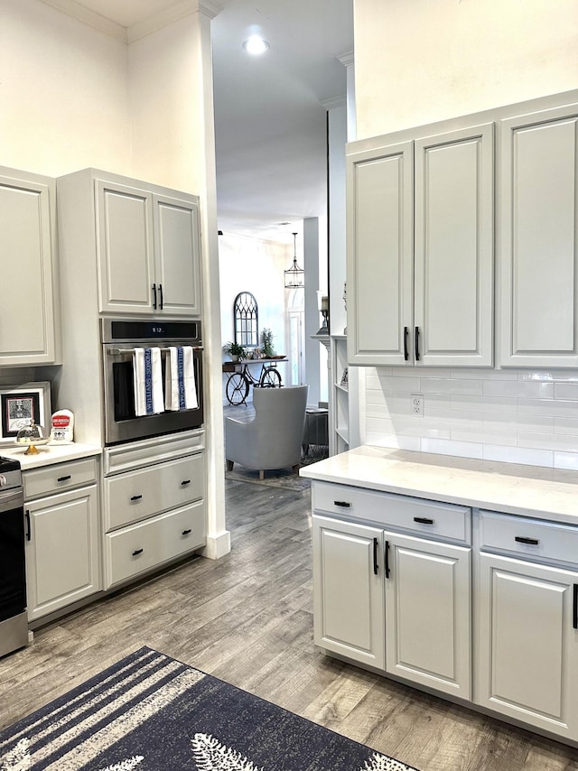 83 Azure Pl, Miramar Beach, FL 32550 - kitchen featuring oven, backsplash, light wood finished floors, crown molding, and a chandelier