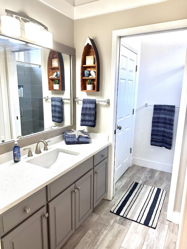 83 Azure Pl, Miramar Beach, FL 32550 - bathroom featuring vanity, wood finished floors, and a stall shower