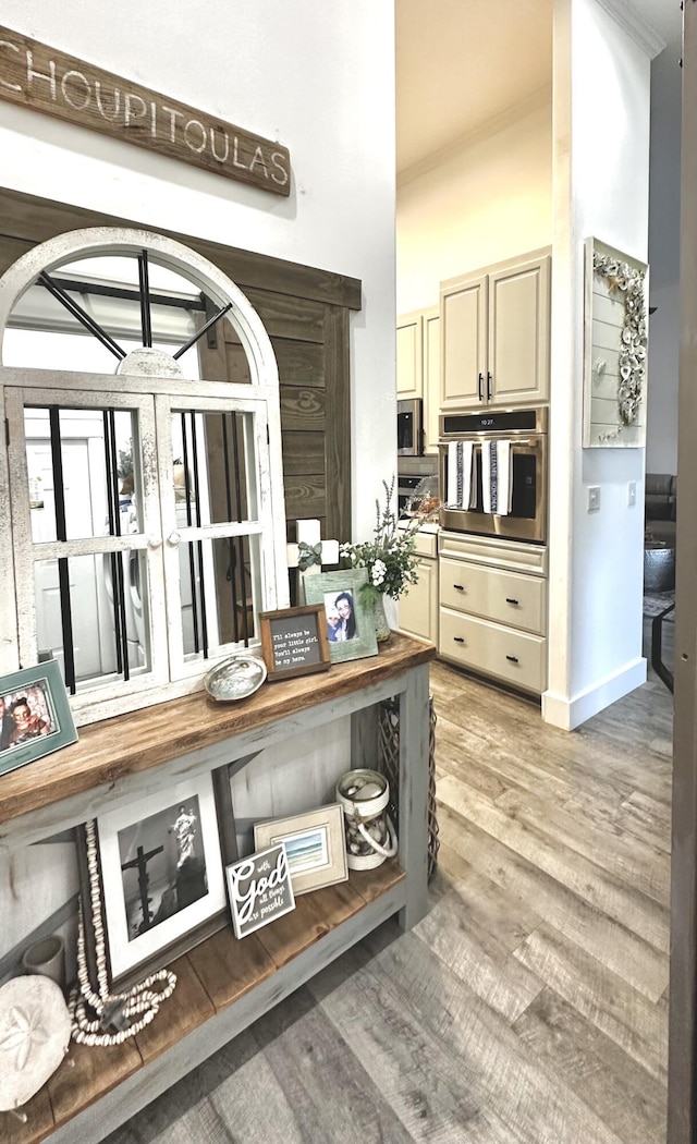 83 Azure Pl, Miramar Beach, FL 32550 - kitchen featuring oven, cream cabinets, crown molding, and light wood-style floors