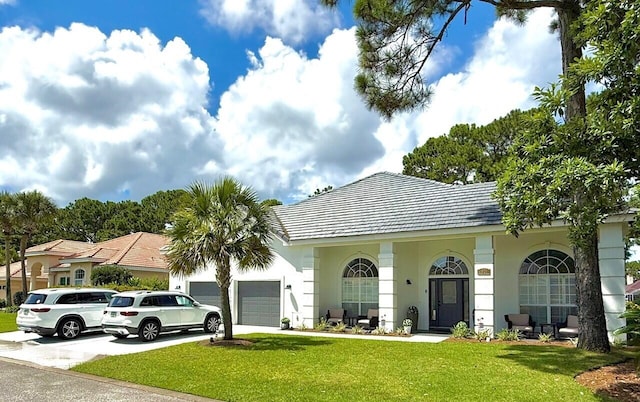 83 Azure Pl, Miramar Beach, FL 32550 - view of front of house featuring stucco siding, a front yard, a garage, and driveway