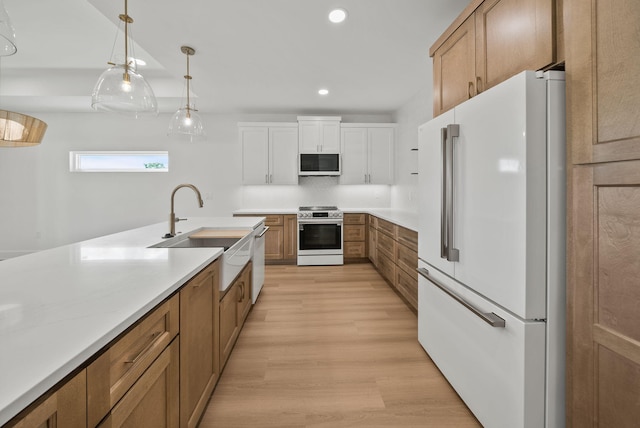 7215 Sunset Ave, Panama City Beach, FL 32408 - kitchen featuring white appliances, recessed lighting, light countertops, light wood-type flooring, and brown cabinetry