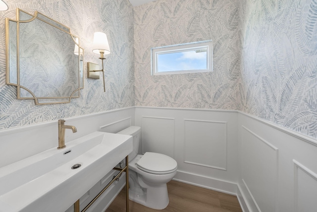 7215 Sunset Ave, Panama City Beach, FL 32408 - half bath with wallpapered walls, a wainscoted wall, wood finished floors, and vanity