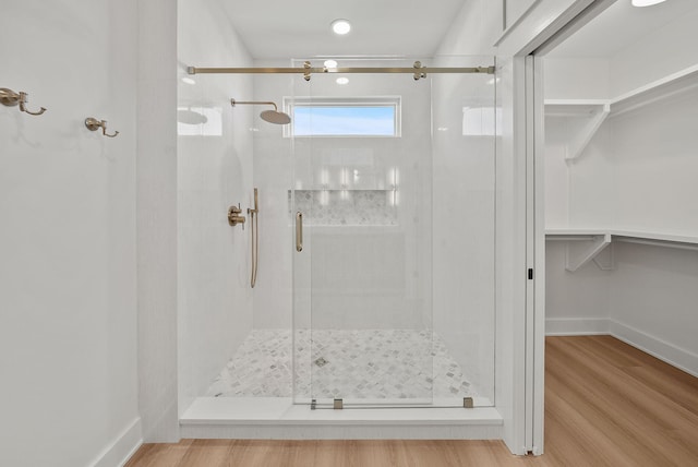 7215 Sunset Ave, Panama City Beach, FL 32408 - bathroom with a stall shower, a walk in closet, and wood finished floors