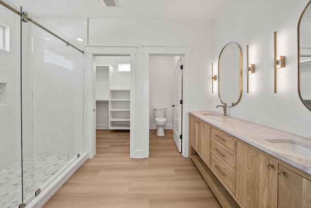 7215 Sunset Ave, Panama City Beach, FL 32408 - bathroom featuring a shower stall, double vanity, wood finished floors, and a closet