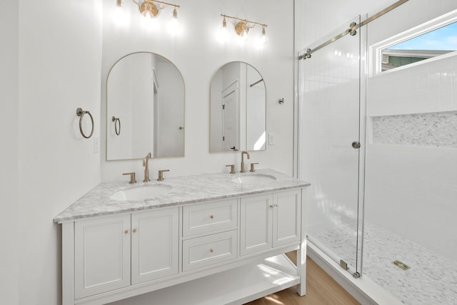 7215 Sunset Ave, Panama City Beach, FL 32408 - bathroom with a tile shower, double vanity, and wood finished floors