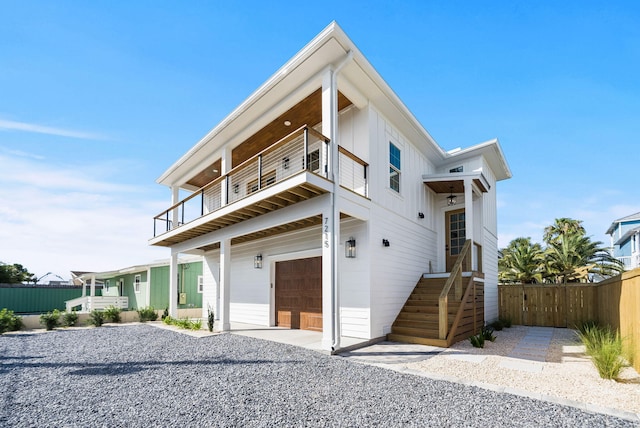 7215 Sunset Ave, Panama City Beach, FL 32408 - view of front of property featuring a balcony, an attached garage, and board and batten siding