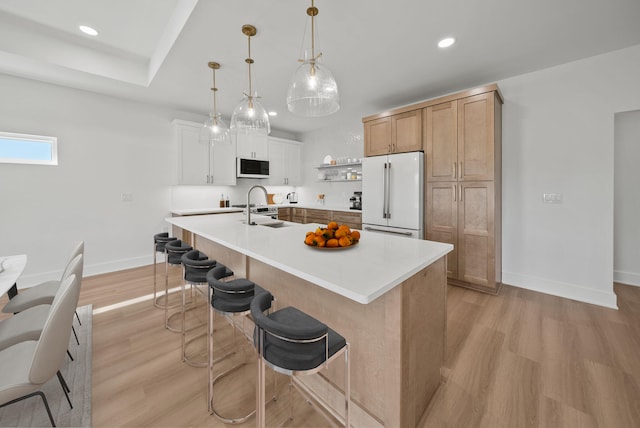 7215 Sunset Ave, Panama City Beach, FL 32408 - kitchen with freestanding refrigerator, light wood-style flooring, light countertops, recessed lighting, and a breakfast bar