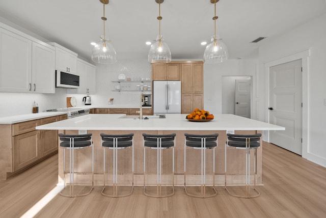 7215 Sunset Ave, Panama City Beach, FL 32408 - kitchen with white appliances, light wood-type flooring, light countertops, and a breakfast bar area