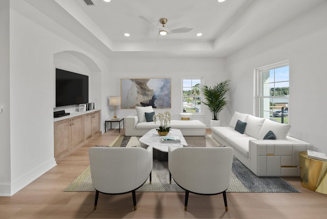 7215 Sunset Ave, Panama City Beach, FL 32408 - living room with light wood finished floors, a ceiling fan, a raised ceiling, recessed lighting, and arched walkways