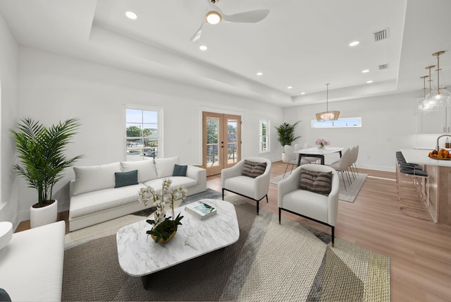 7215 Sunset Ave, Panama City Beach, FL 32408 - living area with a raised ceiling, light wood-style floors, recessed lighting, a ceiling fan, and french doors