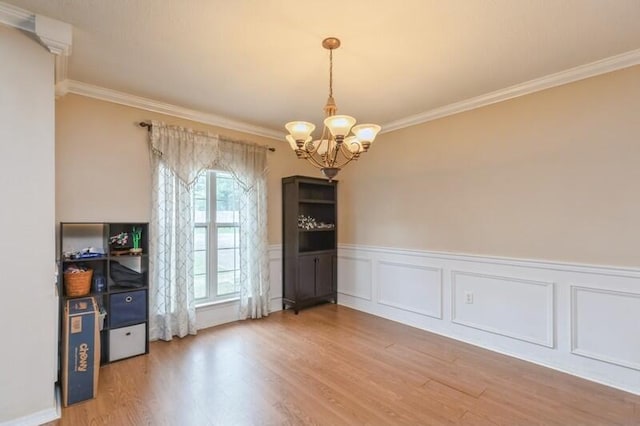 527 Tom Sawyer Ln, Crestview, FL 32536 - unfurnished dining area featuring a chandelier, crown molding, light wood-style flooring, and wainscoting