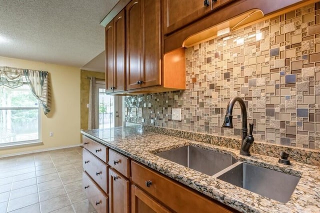 527 Tom Sawyer Ln, Crestview, FL 32536 - kitchen with tasteful backsplash, plenty of natural light, stone countertops, light tile patterned floors, and a textured ceiling