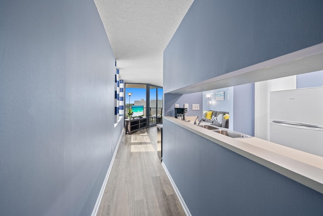 9850 S Thomas Dr Unit 1012W, Panama City, FL 32408 - hall featuring light wood-style flooring and a textured ceiling