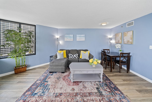 9850 S Thomas Dr Unit 1012W, Panama City, FL 32408 - living area featuring healthy amount of natural light, wood finished floors, and a textured ceiling