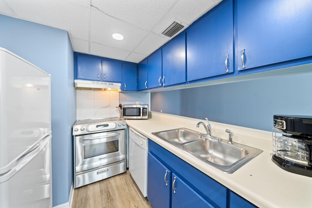 9850 S Thomas Dr Unit 1012W, Panama City, FL 32408 - kitchen with appliances with stainless steel finishes, blue cabinetry, under cabinet range hood, light wood-type flooring, and light countertops