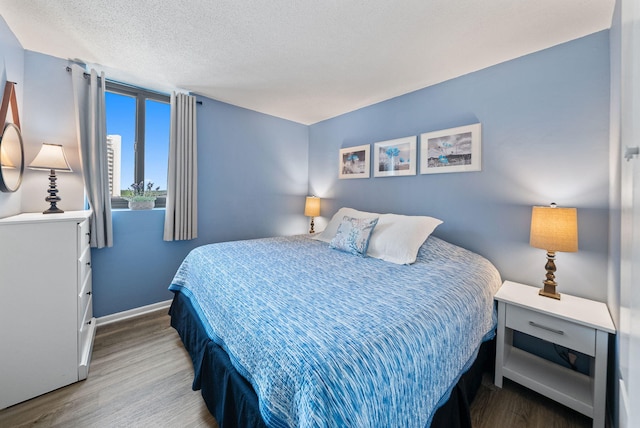 9850 S Thomas Dr Unit 1012W, Panama City, FL 32408 - bedroom with wood finished floors and a textured ceiling