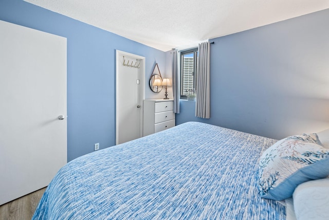 9850 S Thomas Dr Unit 1012W, Panama City, FL 32408 - bedroom featuring wood finished floors and a textured ceiling