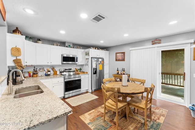1069 Caswell Rd, Defuniak Springs, FL 32433 - kitchen featuring appliances with stainless steel finishes, white cabinetry, dark wood-type flooring, recessed lighting, and light stone counters