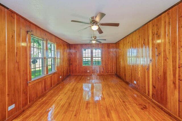 942 Varnum Rd, Laurel Hill, FL 32567 - empty room with light wood-style flooring, wood walls, and a ceiling fan