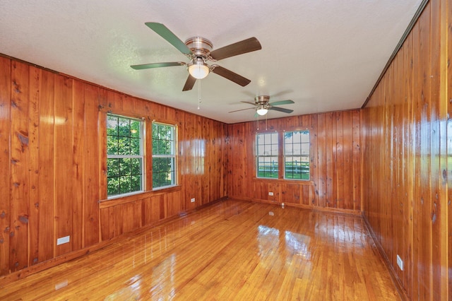 942 Varnum Rd, Laurel Hill, FL 32567 - spare room with healthy amount of natural light, light wood-type flooring, wooden walls, and ceiling fan