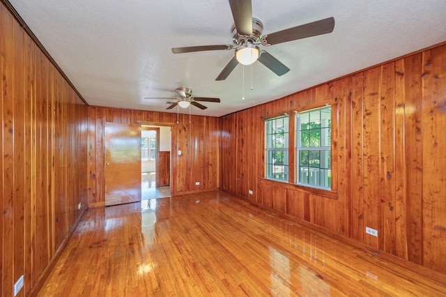 942 Varnum Rd, Laurel Hill, FL 32567 - empty room with plenty of natural light, light wood-style floors, wooden walls, and ceiling fan