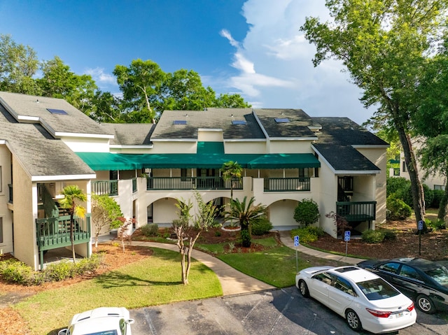 310 Westlake Ct Unit 310, Niceville, FL 32578 - view of front of house with stucco siding, a shingled roof, and uncovered parking