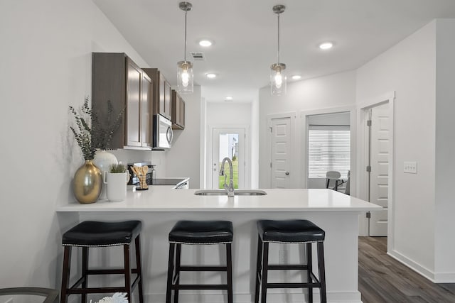 5862 Tyndall Pl, Panama City, FL 32404 - kitchen with stainless steel microwave, a peninsula, dark wood-style floors, light countertops, and recessed lighting