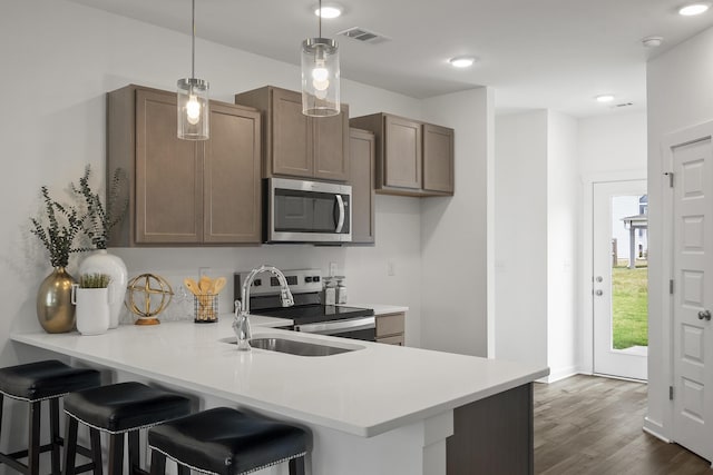 5862 Tyndall Pl, Panama City, FL 32404 - kitchen featuring stainless steel appliances, light countertops, a peninsula, a breakfast bar, and recessed lighting