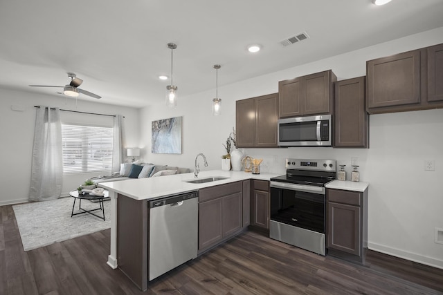5862 Tyndall Pl, Panama City, FL 32404 - kitchen featuring stainless steel appliances, open floor plan, a peninsula, light countertops, and dark wood-style floors