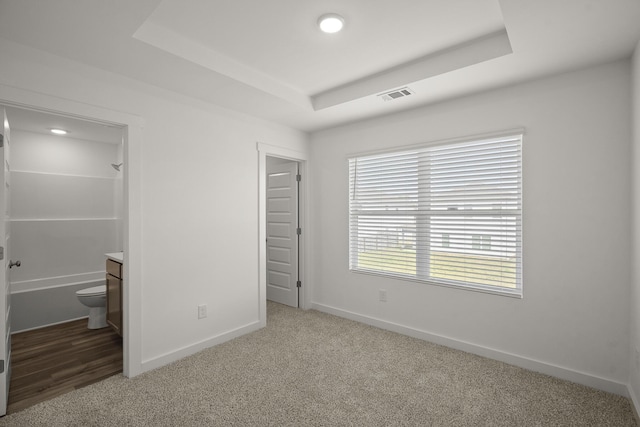 5862 Tyndall Pl, Panama City, FL 32404 - unfurnished bedroom featuring a tray ceiling, light colored carpet, connected bathroom, and recessed lighting
