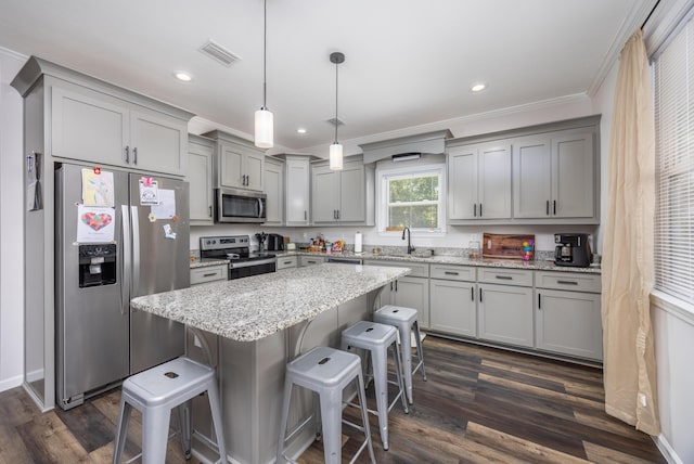 158 Johns Ln, Freeport, FL 32439 - kitchen with stainless steel appliances, gray cabinetry, a kitchen bar, ornamental molding, and dark wood-style floors