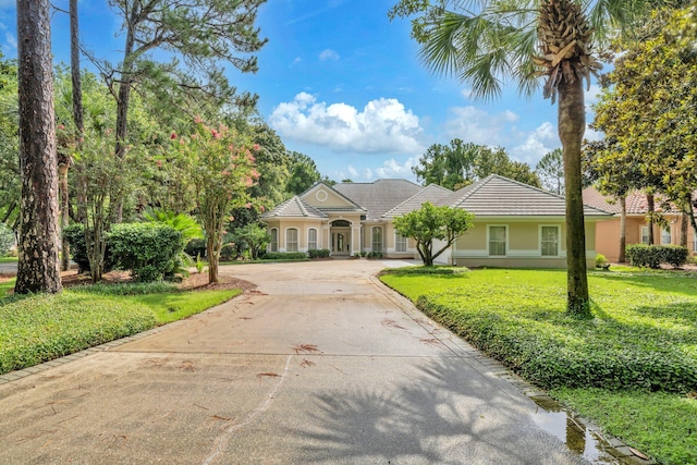 423 Maritime Ct, Destin, FL 32541 - view of front of home featuring a tiled roof, curved driveway, stucco siding, and a front yard
