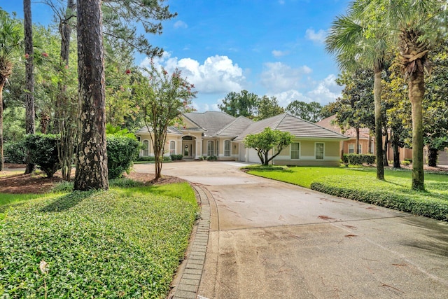 423 Maritime Ct, Destin, FL 32541 - view of front of house with curved driveway, a front lawn, a tiled roof, and stucco siding
