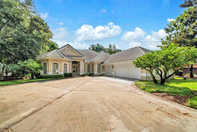423 Maritime Ct, Destin, FL 32541 - view of front of property with concrete driveway, a garage, a tiled roof, and stucco siding