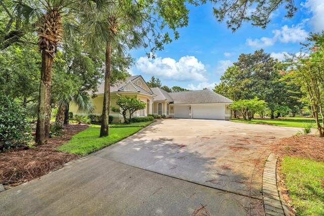 423 Maritime Ct, Destin, FL 32541 - view of front of property with an attached garage, driveway, a tile roof, stucco siding, and a front yard