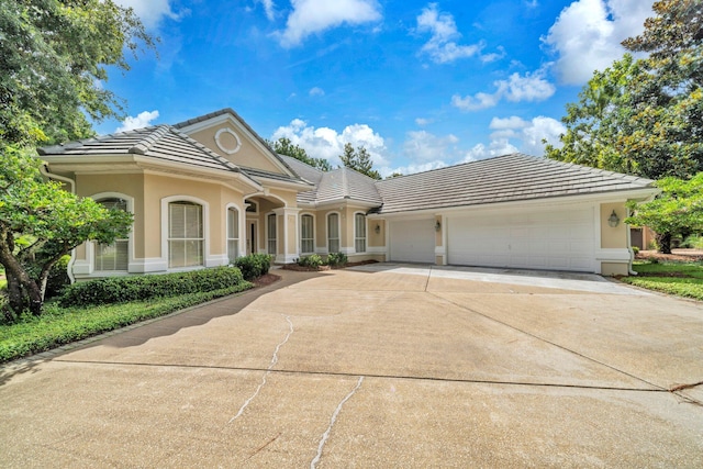 423 Maritime Ct, Destin, FL 32541 - view of front of home with a tiled roof, driveway, an attached garage, and stucco siding