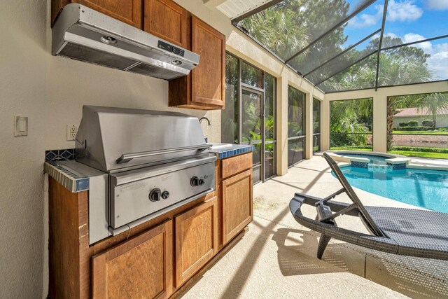 423 Maritime Ct, Destin, FL 32541 - view of pool with exterior kitchen, glass enclosure, a pool with connected hot tub, and a patio