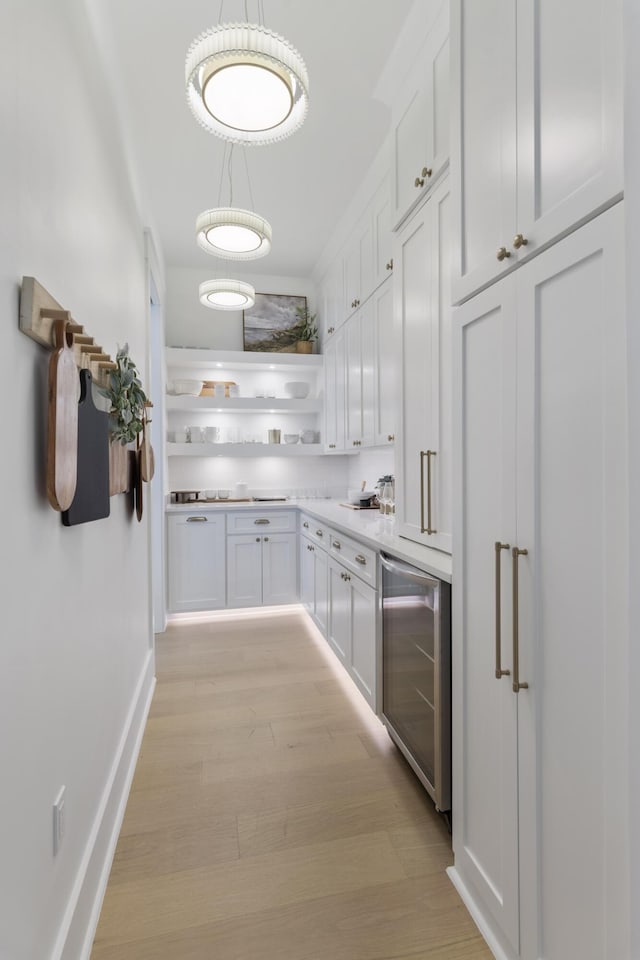 185 Dune Dr, Santa Rosa Beach, FL 32459 - kitchen featuring beverage cooler, open shelves, light wood-style floors, white cabinets, and light countertops
