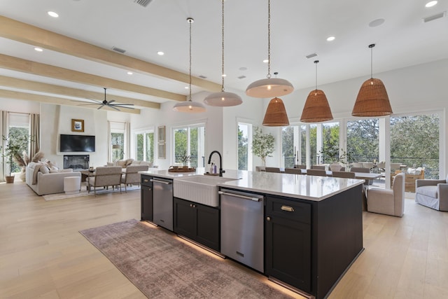 185 Dune Dr, Santa Rosa Beach, FL 32459 - kitchen with dishwasher, open floor plan, dark cabinetry, light countertops, and a center island with sink